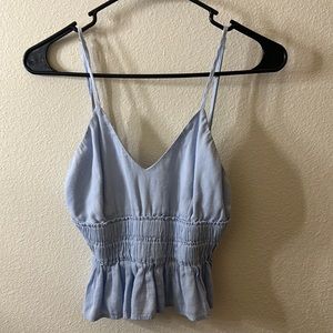 Light blue tank top with adjustable straps and stretchy around the stomach area.